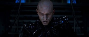 Movie still from “Star Trek: Nemesis” (2002), directed by Stuart Baird – A man in a black suit with a bald head; Close Up shot, Low angle