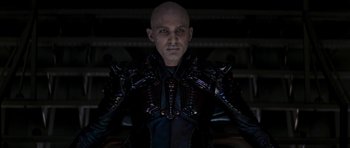 Movie still from “Star Trek: Nemesis” (2002), directed by Stuart Baird – A bald man wearing a black shirt and a black jacket; Medium shot, Low angle