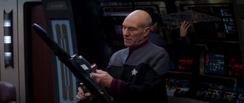 A man in a star trek uniform looking at a tablet