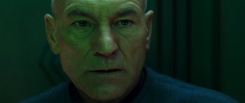 Movie still from “Star Trek: Nemesis” (2002), directed by Stuart Baird – An older man with green eyes stares at the camera; Close Up shot, Low angle