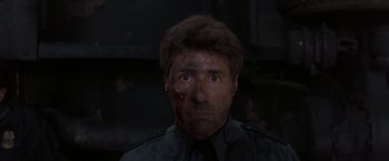 Movie still from “Heat” (1995), directed by Michael Mann – A person with blood on his face; Close Up shot, Low angle