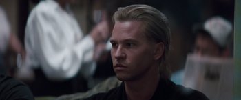 Movie still from “Heat” (1995), directed by Michael Mann – A person with long blonde hair; Close Up shot, Over the shoulder angle