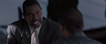 Movie still from “Heat” (1995), directed by Michael Mann – A man wearing a suit and tie talking to another man; Close Up shot, Over the shoulder angle