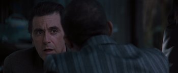 Movie still from “Heat” (1995), directed by Michael Mann – A man talking to another man in a suit; Close Up shot, Over the shoulder angle