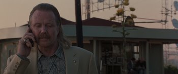 Movie still from “Heat” (1995), directed by Michael Mann – A man with long hair wearing a suit and tie; Close Up shot, Low angle