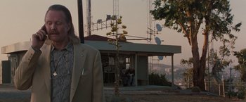 Movie still from “Heat” (1995), directed by Michael Mann – A man standing in front of a building with antennas in the background; Medium shot, Over the shoulder angle