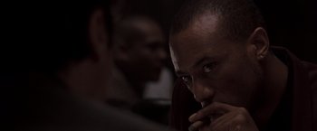 Movie still from “Heat” (1995), directed by Michael Mann – A person with his hand to his face; Close Up shot, Over the shoulder angle