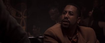 Movie still from “Heat” (1995), directed by Michael Mann – A man sitting in front of another man in a dark room; Close Up shot, Over the shoulder angle