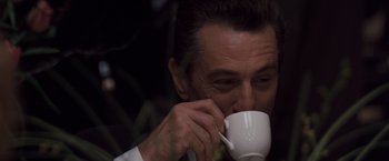 Movie still from “Heat” (1995), directed by Michael Mann – A person drinking a cup of coffee; Close Up shot, Low angle