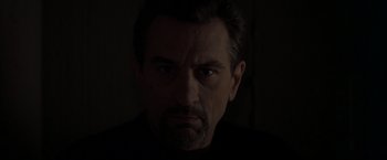 Movie still from “Heat” (1995), directed by Michael Mann – A person in a dark room; Close Up shot, Low angle