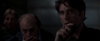 Movie still from “Heat” (1995), directed by Michael Mann – A man sitting next to another man in a dark room; Close Up shot, Low angle
