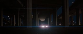 Movie still from “Heat” (1995), directed by Michael Mann – A car driving down a street at night; Extreme Wide shot, Low angle