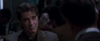 Movie still from “Heat” (1995), directed by Michael Mann – A person wearing a suit and tie; Close Up shot, Over the shoulder angle