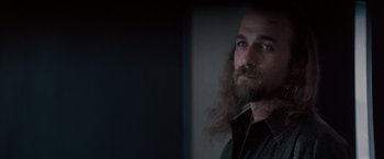Movie still from “Heat” (1995), directed by Michael Mann – A man with long hair and a goatee stares at the camera; Close Up shot, Over the shoulder angle