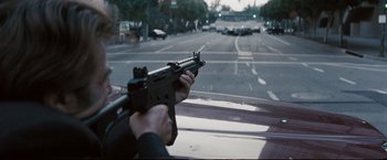 Movie still from “Heat” (1995), directed by Michael Mann – A person holding a gun in the back of a car; Close Up shot, Over the shoulder angle