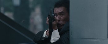 Movie still from “Heat” (1995), directed by Michael Mann – A man holding a gun up to his face; Close Up shot, Low angle