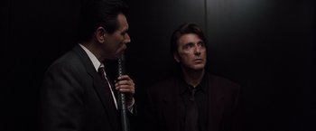 Movie still from “Heat” (1995), directed by Michael Mann – Two men in suits and ties in an elevator; Medium shot, Low angle