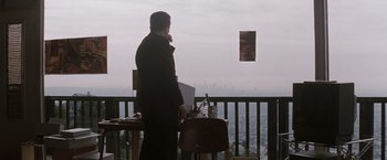 Movie still from “Heat” (1995), directed by Michael Mann – A man standing in front of an easel on a balcony; Wide shot, Low angle