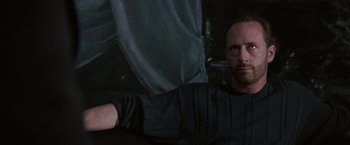 Movie still from “Heat” (1995), directed by Michael Mann – A man in a black shirt is looking at the camera; Close Up shot, Low angle