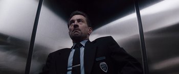 Movie still from “Heat” (1995), directed by Michael Mann – A man in a suit and tie looking upward; Close Up shot, Low angle