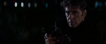 Movie still from “Heat” (1995), directed by Michael Mann – A person holding a gun; Close Up shot, Over the shoulder angle