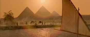 Movie still from “Stargate” (1994), directed by Roland Emmerich – A group of people standing on top of a sandy beach; Extreme Wide shot, Low angle