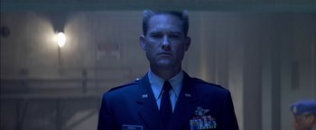 Movie still from “Stargate” (1994), directed by Roland Emmerich – A man in a military uniform is looking at the camera; Close Up shot, Low angle