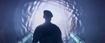 Movie still from “Stargate” (1994), directed by Roland Emmerich – A man standing in front of a tunnel with lights; Medium shot, Low angle