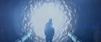 Movie still from “Stargate” (1994), directed by Roland Emmerich – A man standing in front of a light that is shining on it; Wide shot, Low angle