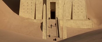 Movie still from “Stargate” (1994), directed by Roland Emmerich – A group of people climbing up the side of a building; Extreme Wide shot, High angle