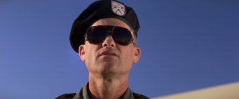Movie still from “Stargate” (1994), directed by Roland Emmerich – A person wearing sunglasses and a hat; Close Up shot, Low angle