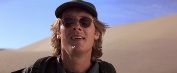 Movie still from “Stargate” (1994), directed by Roland Emmerich – A person wearing sunglasses and a hat; Close Up shot, Low angle