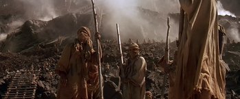 Movie still from “Stargate” (1994), directed by Roland Emmerich – A group of people standing on top of a mountain; Wide shot, Low angle