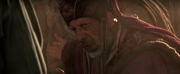Movie still from “Stargate” (1994), directed by Roland Emmerich – An older man with a beard and a hat; Close Up shot, Over the shoulder angle