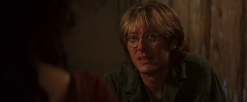 Movie still from “Stargate” (1994), directed by Roland Emmerich – A man with glasses is sitting in a chair; Close Up shot, Over the shoulder angle