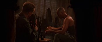 Movie still from “Stargate” (1994), directed by Roland Emmerich – Two men sitting in a room smoking and drinking; Medium shot, Low angle