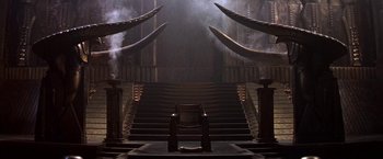 Movie still from “Stargate” (1994), directed by Roland Emmerich – A chair sitting on top of a set of stairs; Extreme Wide shot, High angle
