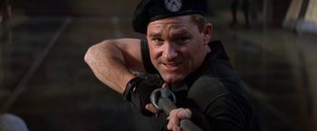 Movie still from “Stargate” (1994), directed by Roland Emmerich – A man holding a hammer in his hand; Close Up shot, Low angle