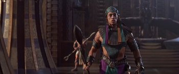 Movie still from “Stargate” (1994), directed by Roland Emmerich – A man with a spear in his hand and an arrow in his other hand; Medium shot, Over the shoulder angle