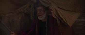 Movie still from “Stargate” (1994), directed by Roland Emmerich – An old man with a long beard wearing a hat; Medium shot, Low angle