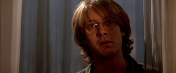 Movie still from “Stargate” (1994), directed by Roland Emmerich – A person wearing glasses; Close Up shot, Over the shoulder angle