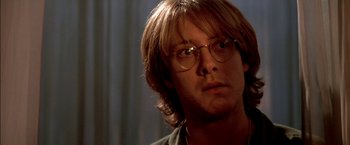 Movie still from “Stargate” (1994), directed by Roland Emmerich – A person wearing glasses; Close Up shot, Over the shoulder angle