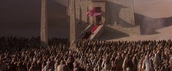 Movie still from “Stargate” (1994), directed by Roland Emmerich – A crowd of people gathered in front of a building; Extreme Wide shot, High angle