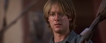 Movie still from “Stargate” (1994), directed by Roland Emmerich – A person wearing glasses and a shirt; Close Up shot, Over the shoulder angle