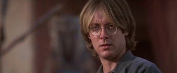 Movie still from “Stargate” (1994), directed by Roland Emmerich – A person wearing glasses; Close Up shot, Over the shoulder angle
