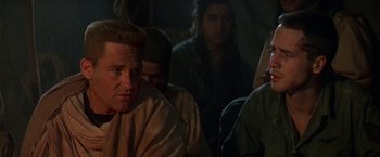 Movie still from “Stargate” (1994), directed by Roland Emmerich – A group of people sitting in a room; Close Up shot, Over the shoulder angle