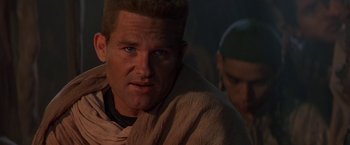 Movie still from “Stargate” (1994), directed by Roland Emmerich – A person wearing a blanket; Close Up shot, Low angle