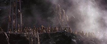 Movie still from “Stargate” (1994), directed by Roland Emmerich – A group of people standing on top of a mountain; Extreme Wide shot, High angle