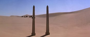 Movie still from “Stargate” (1994), directed by Roland Emmerich – A couple of large stone obelisks in the desert; Extreme Wide shot, Low angle