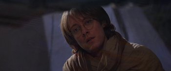 Movie still from “Stargate” (1994), directed by Roland Emmerich – A man wearing glasses and a sweater; Close Up shot, Over the shoulder angle
